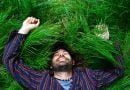 Homme content qui profite de la vie allongé dans l'herbe, il est en bonne santé gtace aux plantes medicinales